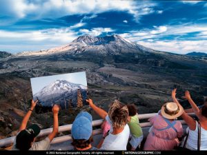 Group comparing photo of mountain to the real thing