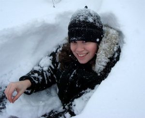 Woman peering out of snow fort