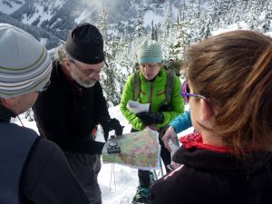 Studying a map while winter hiking on mountain trail