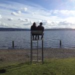 Couple in lifeguard chair on pebbly beach